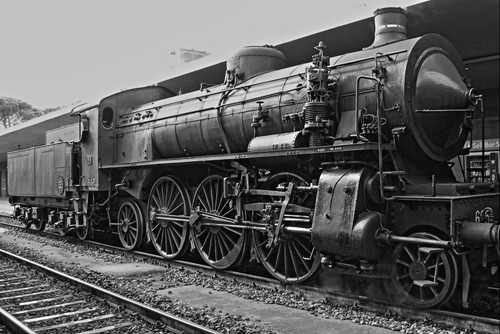 Immagine con locomotiva, ruote, binari, bianconero, treno, tender, ferrovia, traversine, rotaie, binario, cabina, vagone, stantuffi, locomotore, stazione