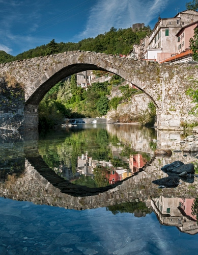 Immagine con ponte, riflesso, fiume, case, acqua, arco, alberi, cielo, riflessi, verde, pietra, cerchio, pietre, rocce, azzurro, nuvole, bosco
