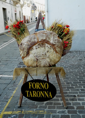 Immagine con insegna, pane, fiori, cavalletto, forno, spighe