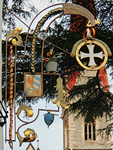 Immagine con croce, insegna, stemma, campanile, oro, aquila, metallo, albero, finestra, vaso