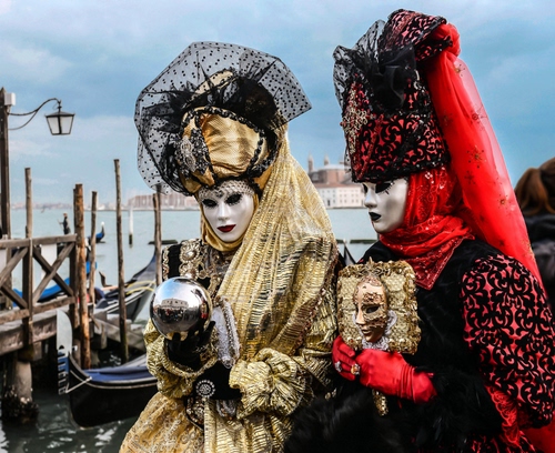 Immagine con venezia, maschere, carnevale, gondole, rosso, lampione, mare, oro, sfera, pali, laguna, donne, nero, gondola, guanti, pontile, costumi