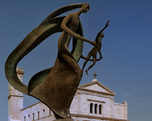 Immagine con chiesa, croce, monumento, campanile, donna, cielo, bronzo, statua, ferro